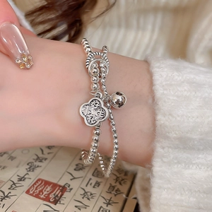 Detail of silver double-layer beaded bracelet with bell and engraved Ruyi cloud pendant