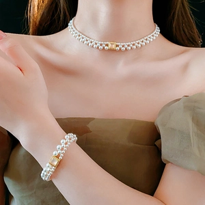 Detail of 18k gold plated necklace with woven white pearls and pink gemstone pendant