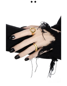 Close-up of golden irregular wavy S925 silver rings worn on hands with black nails