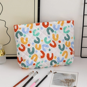 Detailed view of a quilted makeup bag featuring colorful U-shaped patterns and soft texture