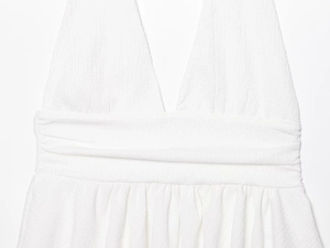 Dettaglio della trama del tessuto in crespo bianco del top a fascia con scollo all'americana