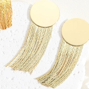 Macro shot of gold tassel drop earrings with smooth round discs and snake chain details
