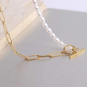 Macro detail of half-pearl half-paperclip chain necklace with gold OT toggle clasp