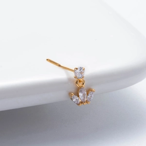 Golden crown nose stud with sparkling cubic zirconia on a white surface
