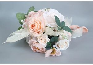 Detailed close-up of bridal bouquet with pink roses, white flowers and pearl accents