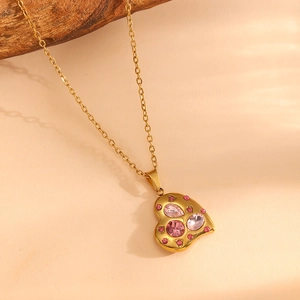 Macro detail of 18K gold-plated heart pendant with pink crystals and shimmering gems