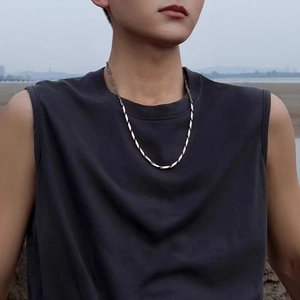 Photo lifestyle d'un collier à maillons en losange en acier titane argenté sur un mannequin