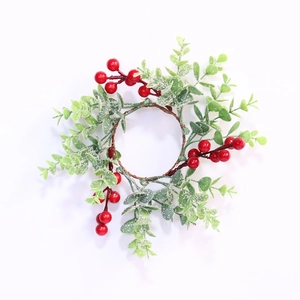 Detailed top view of a festive Christmas candle ring with red berries and snowy leaves