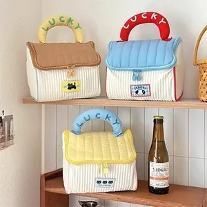 Detailed shot of three quilted cosmetic bags with lucky embroidery and stripe prints