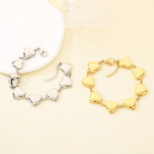 Détail de bracelets cœur creux en or et argent avec fermoir mousqueton réglable