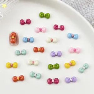 Macro shot of 3D colorful resin bow nail charms in candy colors on white ceramic plate