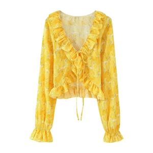 Close-up of yellow floral blouse showing ruffled edges and delicate tie-up detail