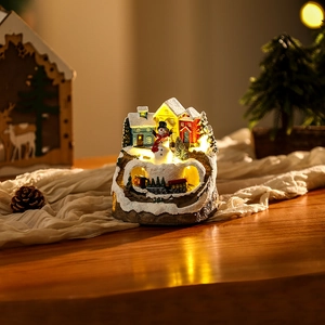 Close-up of a Christmas resin snow house with LED lighting and a rotating toy train