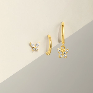Detailed view of gold butterfly stud earrings and hoops set with sparkling cubic zirconia