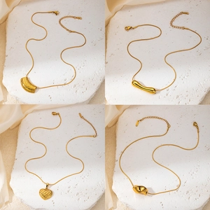 Golden titanium steel necklace set with heart and geometric pendants on silk background