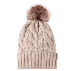 Women's beige knitted beanie with cable knit pattern and large faux fur pompom decoration
