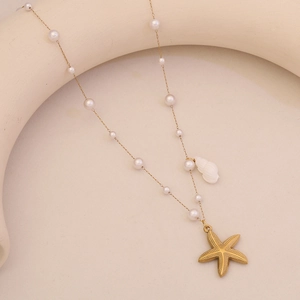 Close-up of gold chain necklace with white pearls, shell and starfish pendants