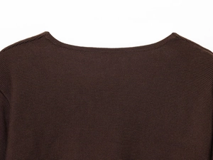 Detail shot of the neckline craftsmanship and fine knit texture on a brown knitted cardigan