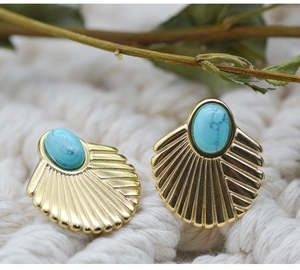 Detailed macro view of bohemian fan-shaped gold earrings with blue turquoise stones