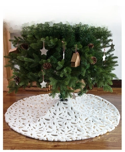 Detail of white plush Christmas tree skirt with elegant gold foil feather patterns