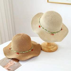 Women's straw sun hat with wavy brim and cherry vine decor for beach sun protection