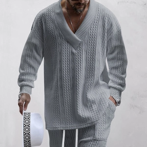 Detailed macro shot of gray cable-knit texture on long-sleeve V-neck sweater and pants