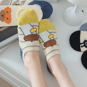 Detail of yellow cotton no-show socks featuring cute cartoon duck pattern and soft texture