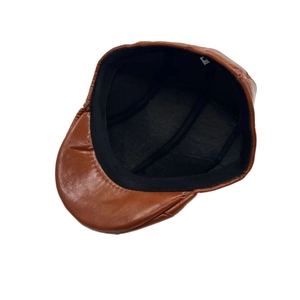 Deep brown faux leather newsboy cap showing inner black lining and soft texture