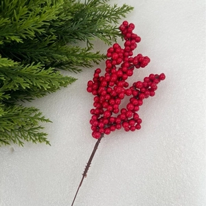 Detailed view of red artificial holly berries on a brown stem for festive home decor