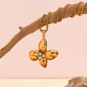 Detail of 18K gold-plated clover pendant with three rhinestones on a delicate chain