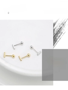 Macro detail of minimalist S925 silver stud earrings with zirconia and gold plating
