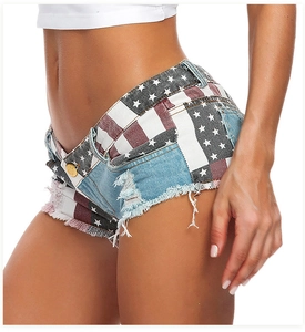 Dettaglio laterale degli shorts in denim a vita bassa con stampa bandiera americana