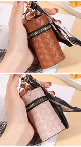 Detail of woven cylinder pouch with golden hardware and floral ribbon accent