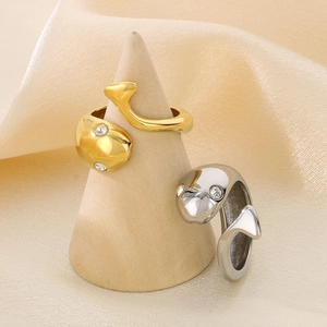 Detail of dolphin wrap rings in 18k gold and silver finish with crystal settings