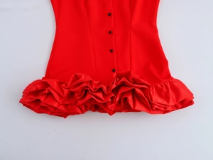 Detail view of red mini skirt featuring tiered ruffle hem and vertical black buttons