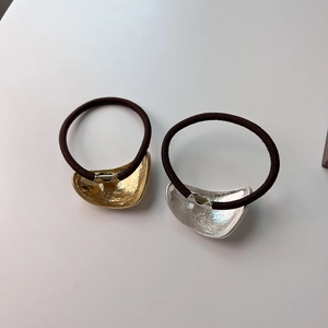 Detail of minimalist hair tie set with irregular hammered metal texture in gold and silver
