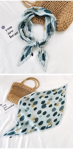 Detailed view of pleated silk scarf with abstract geometric patterns and polka dots