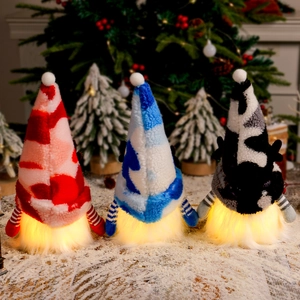 Three glowing Christmas gnomes with reindeer antlers and plaid hats on snowy background