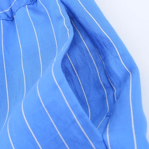 Close-up of blue fabric with white vertical stripes showing material texture and seams