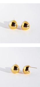 Detailed views of gold teardrop stud earrings with polished metallic surface on white background