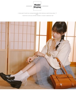 Detailed view of white knit socks with lace trim and large sheer bow on the heel