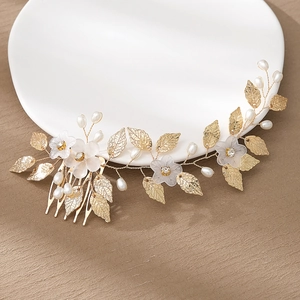Elegant gold bridal hair comb with pearls and white floral accents for traditional styling