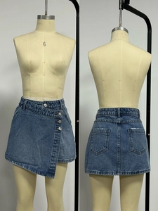Vue détaillée d'une mini-jupe en jean asymétrique avec fermeture à boutons croisés