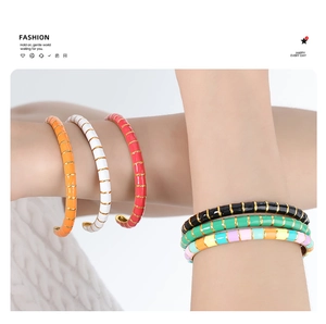 Detail of colorful enamel bamboo-style bracelets with gold segments worn by model