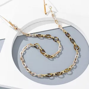 Detailed close-up of amber and cream acrylic eyeglass chain with gold link accents