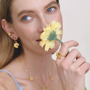 Conjunto de joyas margarita dorada con circón naranja lucido por modelo elegante