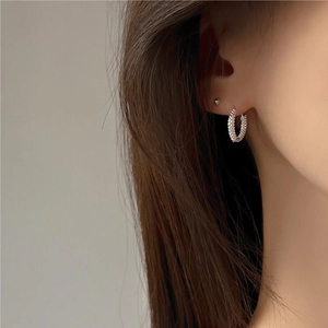 Close-up of sparkling silver hoop earrings with pave set crystals on model