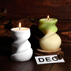 Détail de bougies parfumées en spirale torsadée sur socle bois avec flamme