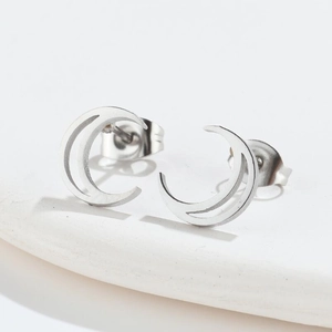 Detailed view of silver hollow crescent moon stud earrings on a white minimalist pedestal