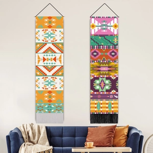 Bohemian wall tapestry with geometric prints and tassels displayed over a blue sofa